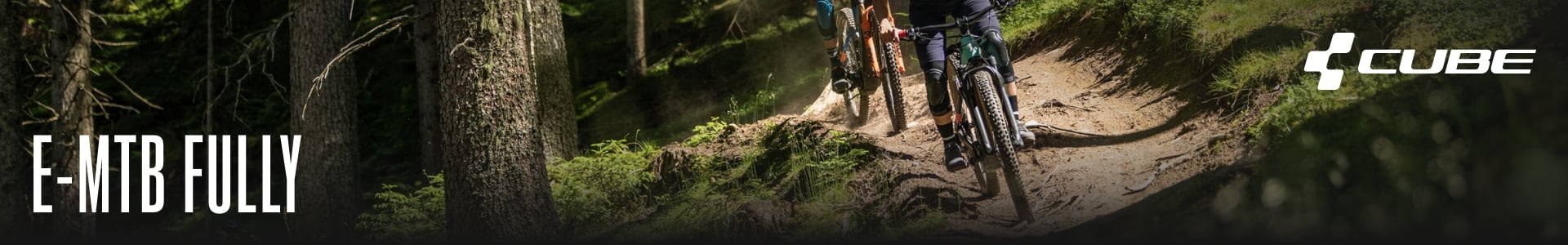 Zwei Personen fahren mit CUBE E-MTB Fully durch einen Waldweg, umgeben von Bäumen und Moos.