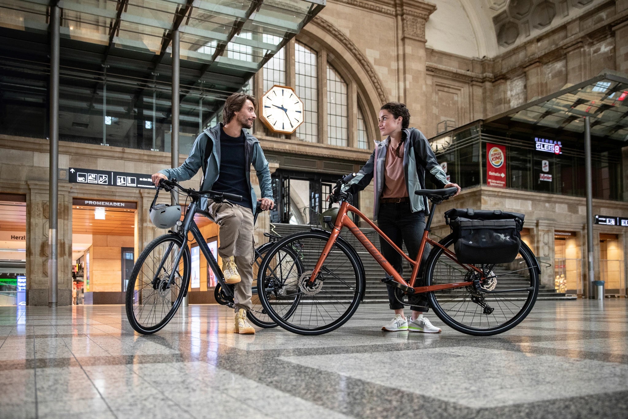 Zwei Personen, die in einem Bahnhof auf Diamant-Fahrrädern stehen, ideal für urbane Mobilität.
