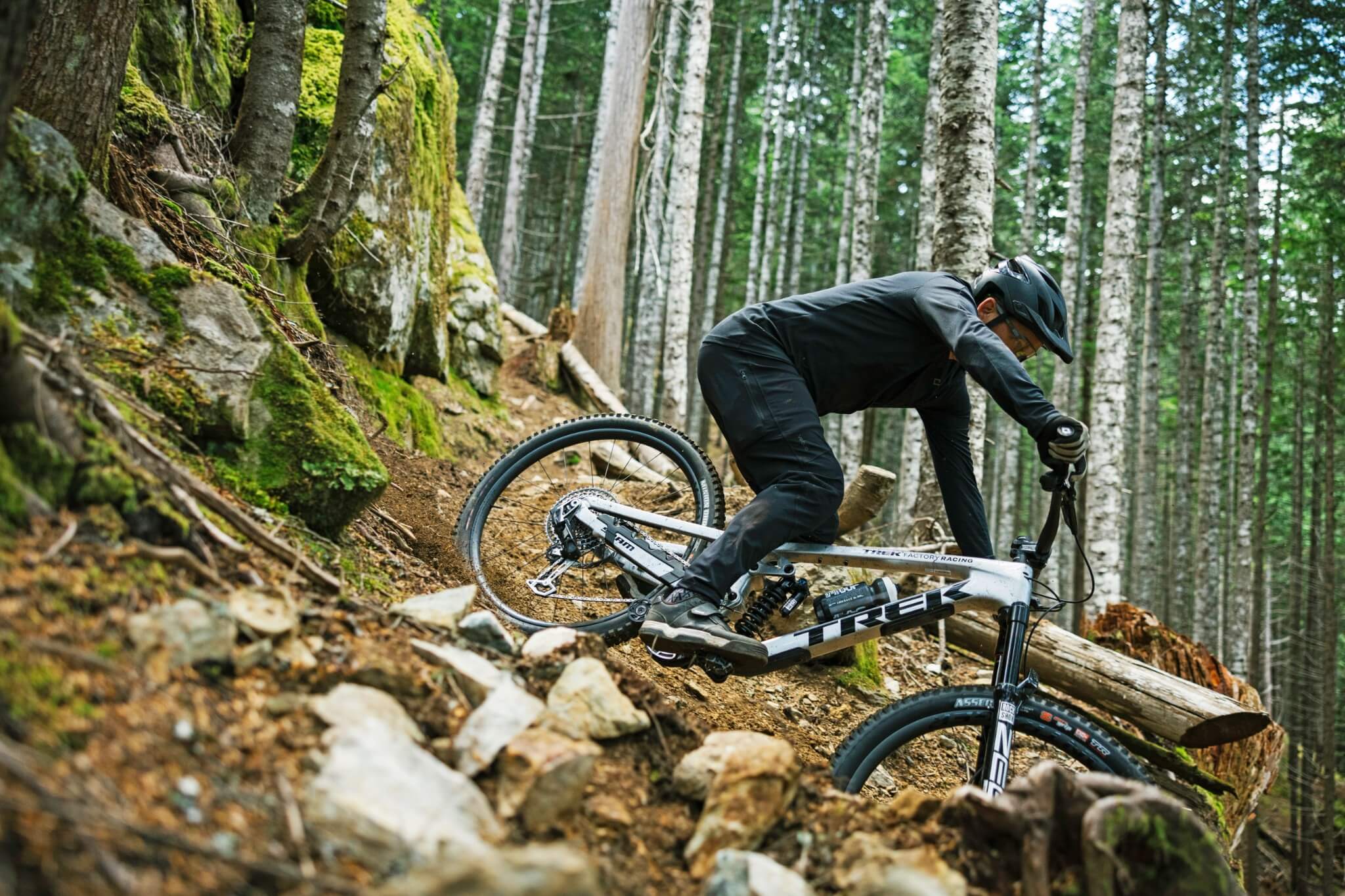 Mountainbiker fährt mit Trek Bike durch steinigen Waldhang. Ideal für Downhill-Enthusiasten und Abenteurer.