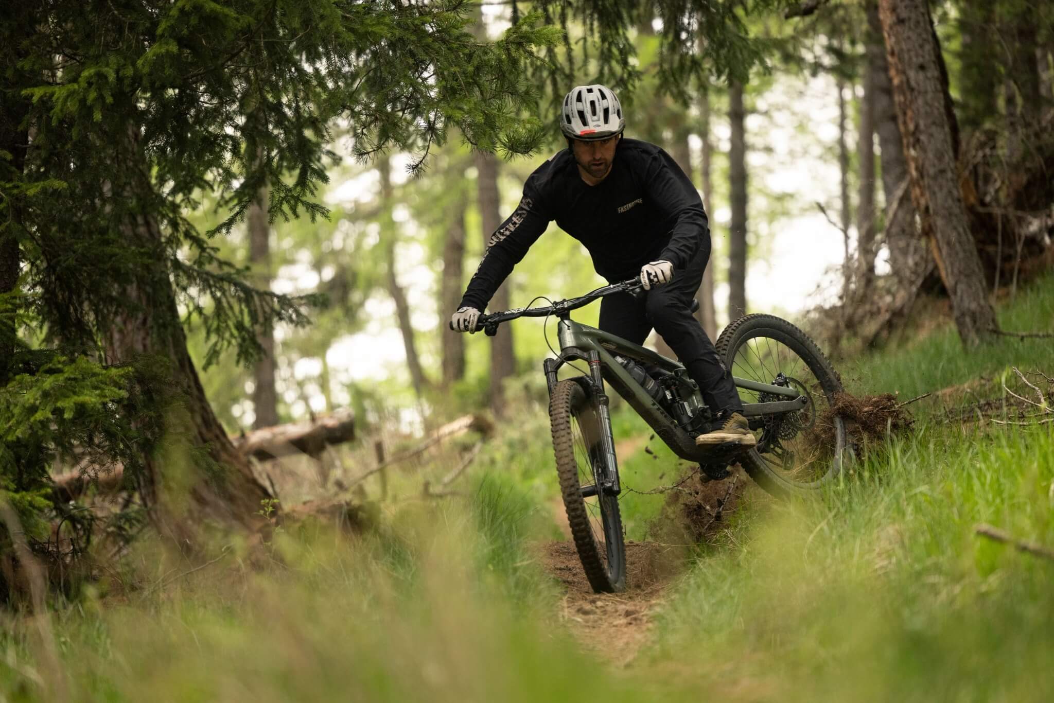 Mountainbiker fährt den Trek Slash durch einen Waldpfad; ideal für Offroad-Abenteuer und Trail-Enthusiasten.