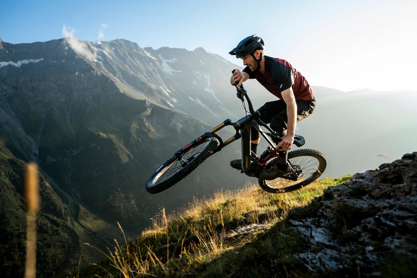 Mountainbiker auf einem Orbea Wild Fahrrad, steile Abfahrt in alpiner Landschaft, ideal für abenteuerlustige Radfahrer.