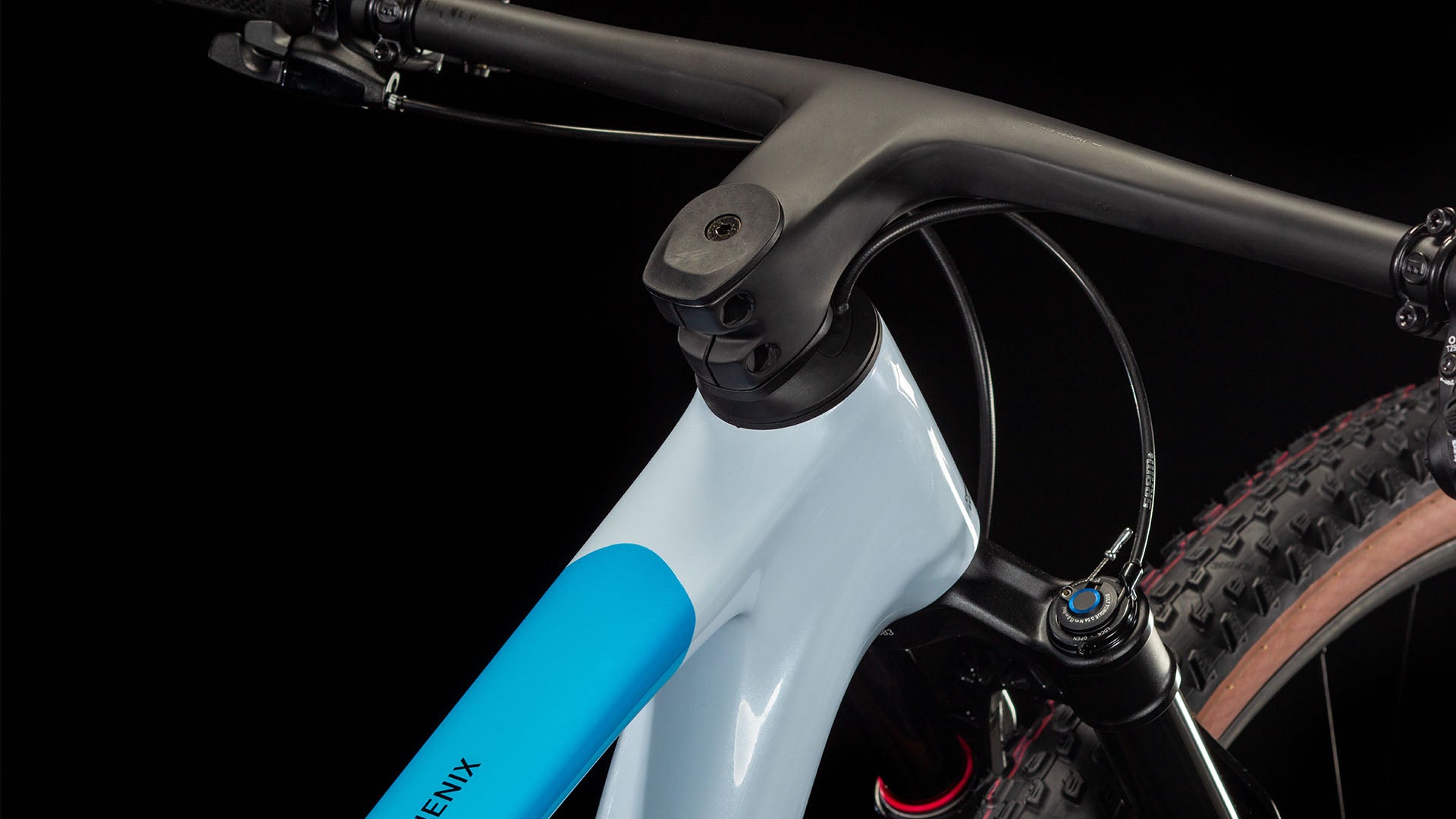 Nahaufnahme: Weiß-blauer Fahrradrahmen Cube Phenix, Fokus auf Lenkung und Federungsteil, ideal für Mountainbiker.