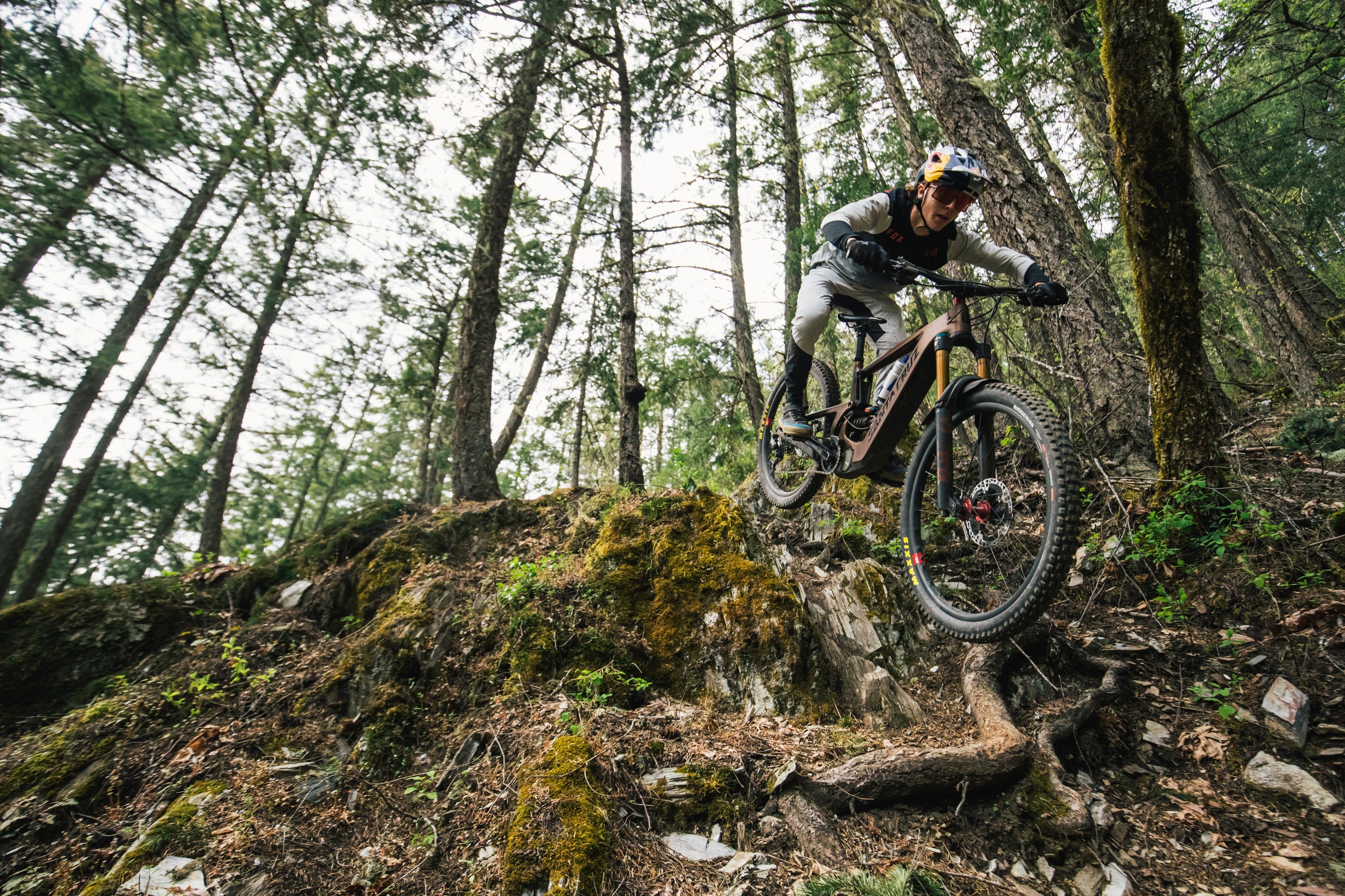 Mountainbiker fährt mit Santa Cruz E-MTB steilen Waldpfad hinab, ideal für Offroad-Enthusiasten.