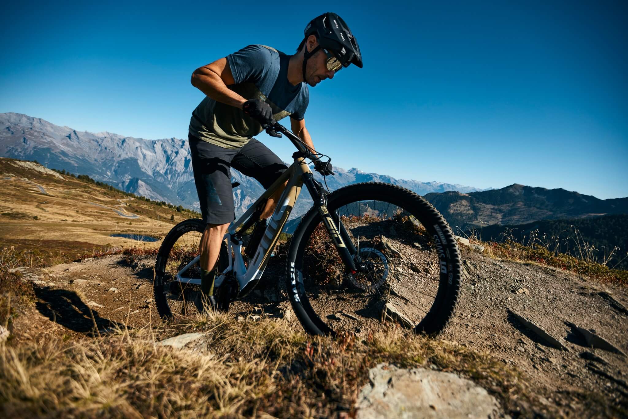 Radfahrer auf dem BMC Fourstroke AMP Mountainbike in Berglandschaft. Ideal für Offroad-Abenteuer und sportliche Fahrer.