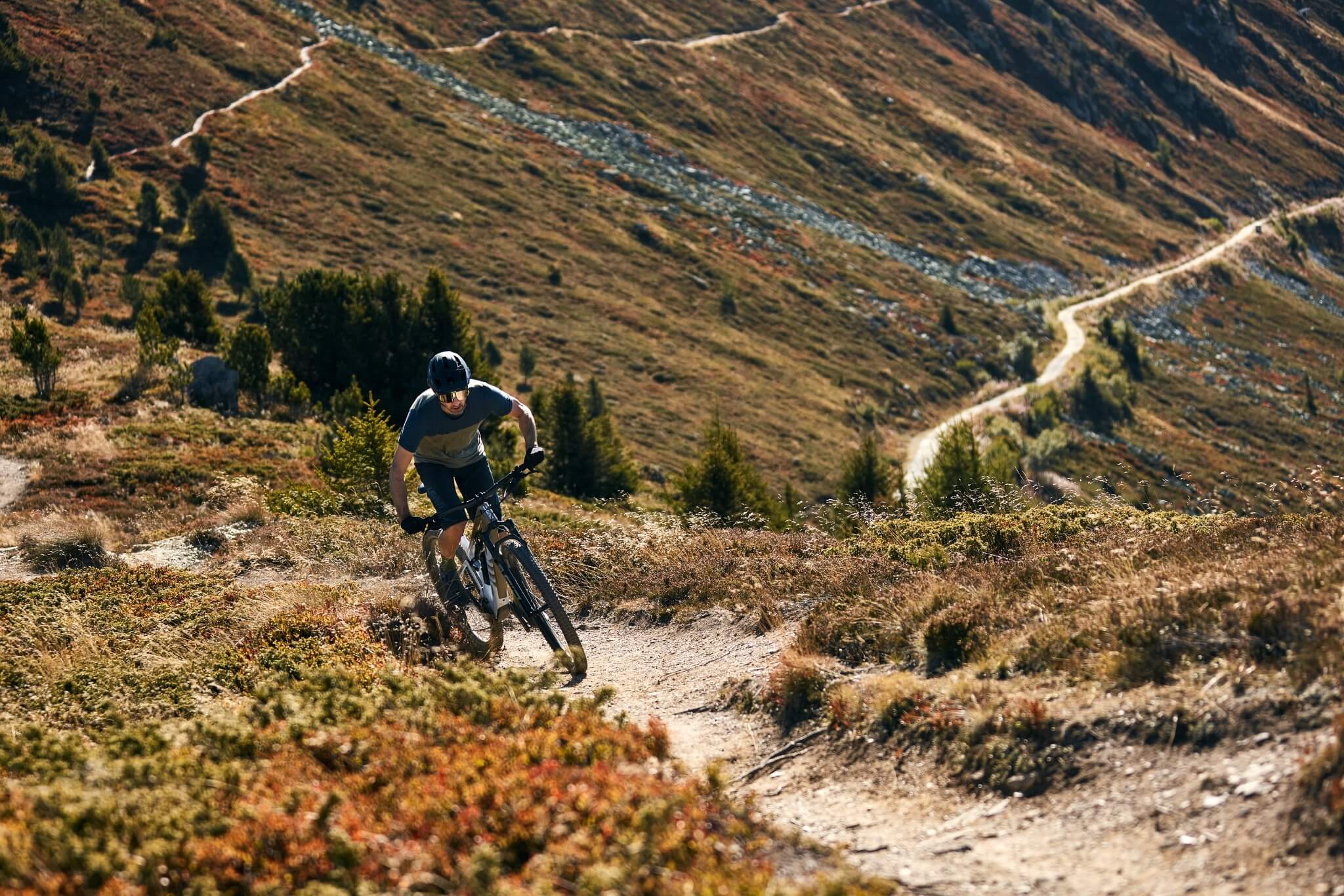 Fahrradfahrer auf steinigem Bergpfad mit BMC E-Bike. Passend für Offroad-Abenteuer in bergiger Landschaft.