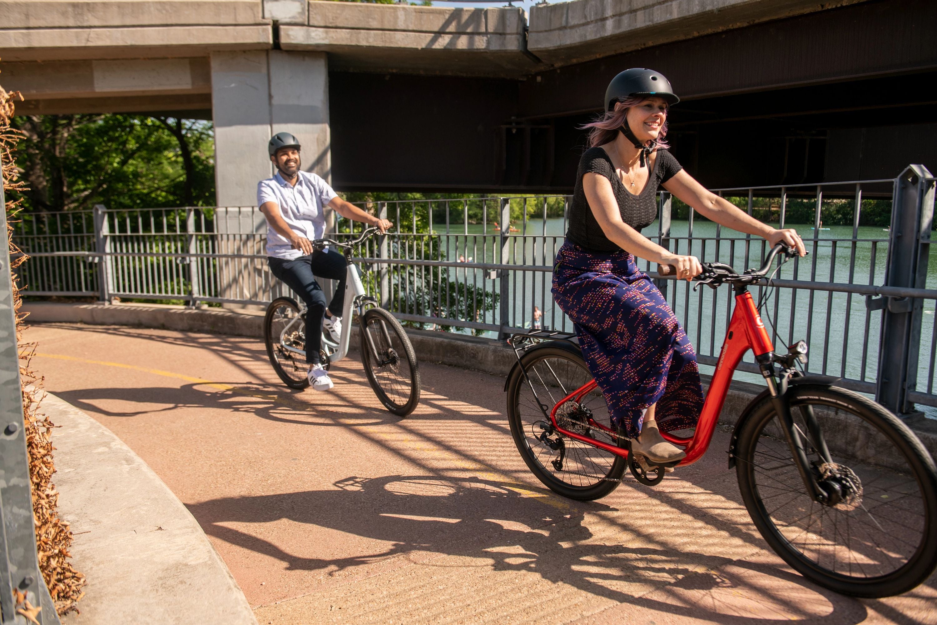 Zwei Personen fahren auf einem Weg mit Cannondale Fahrrädern, tragen Helme, entspanntes Stadt- oder Freizeitfahren.