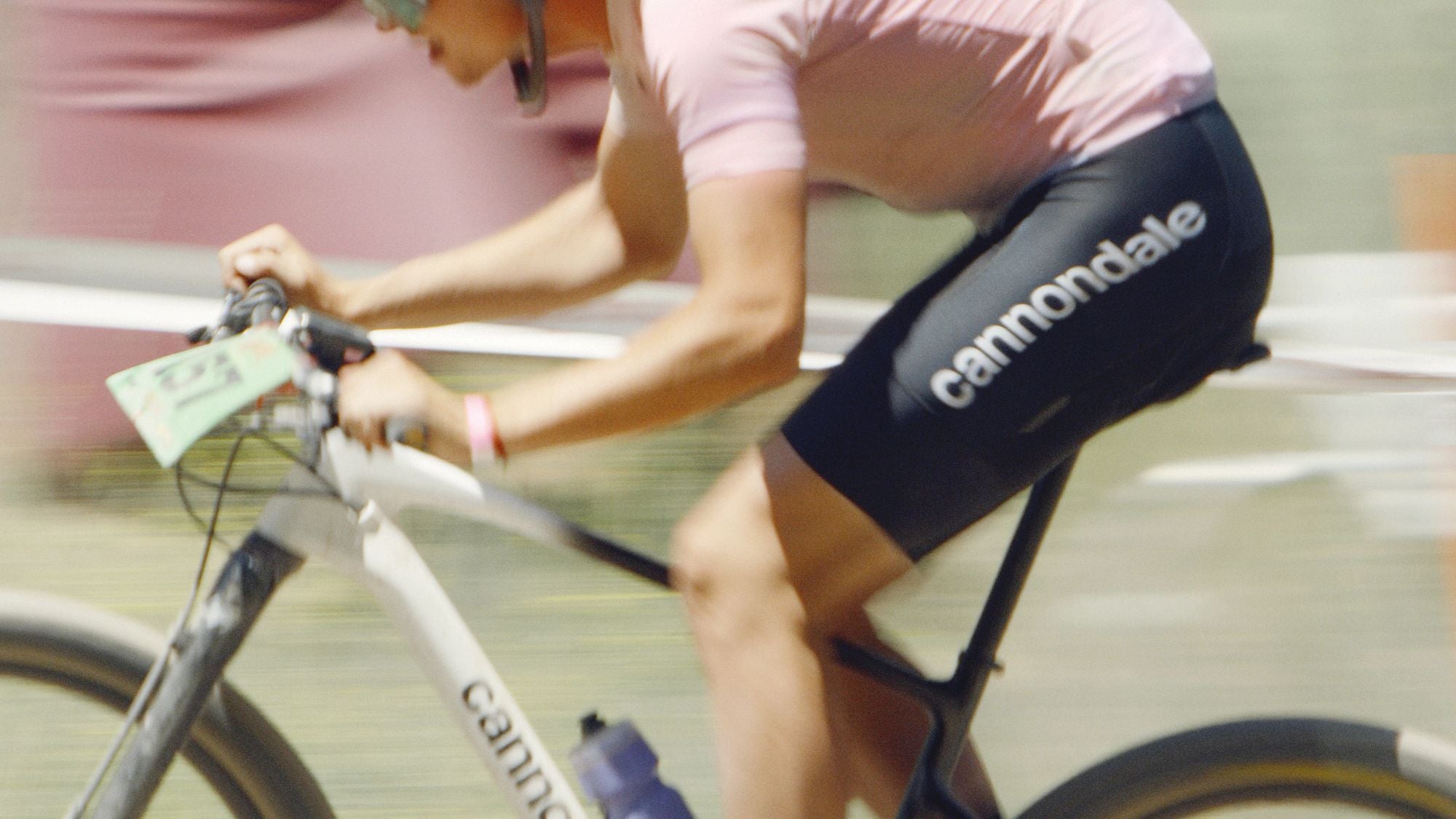 Radfahrer im rosa Trikot auf einem weißen Cannondale Hardtail-Mountainbike beim Rennen.