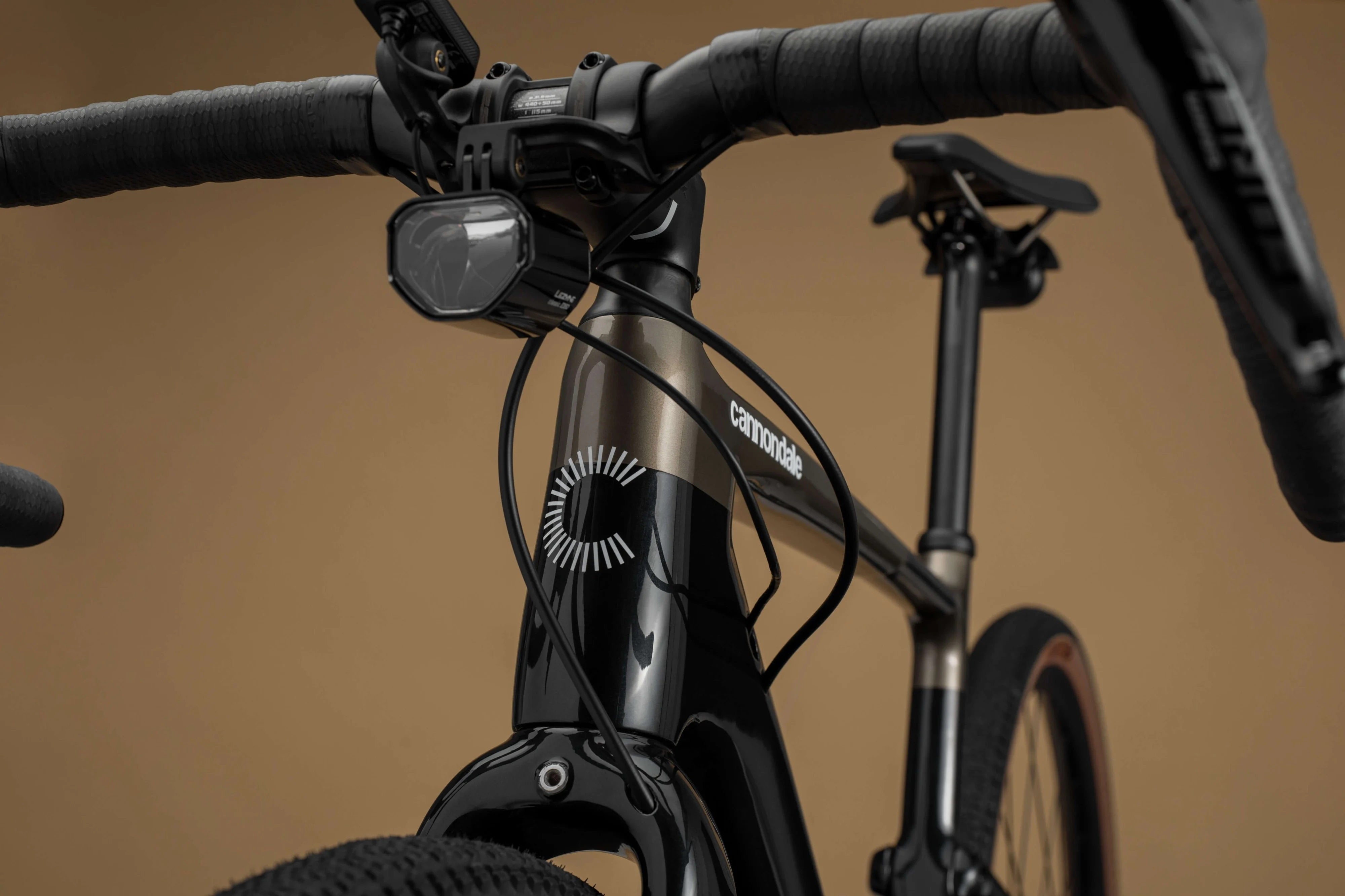 Nahaufnahme eines Cannondale Topstone Fahrrads, zeigt Lenker, Scheinwerfer und Rahmen für Sport- und Pendlerzwecke.