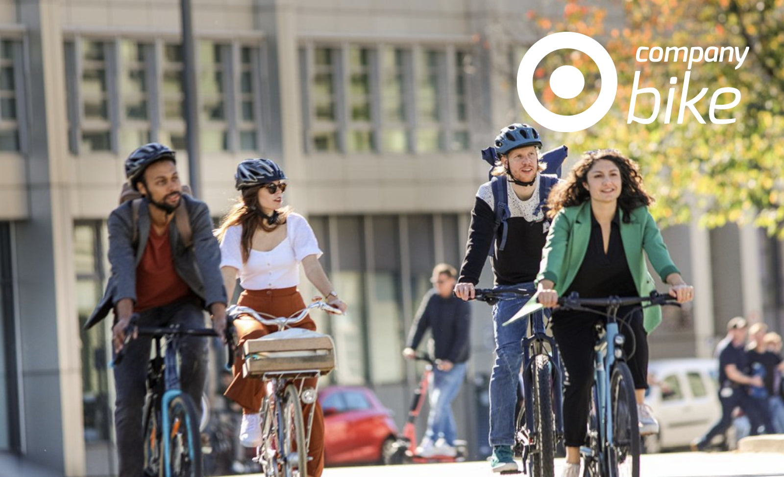 Vier Menschen fahren mit Fahrrädern im urbanen Umfeld, alle tragen Helme. Logo von Company Bike links oben.