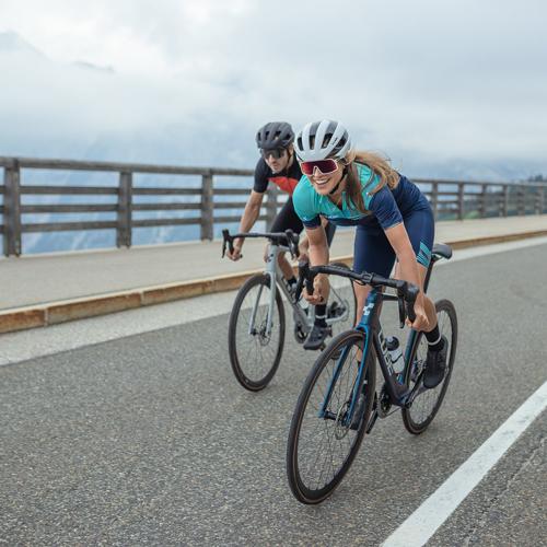 Zwei Radfahrer in Rennbekleidung auf einer Straße in den Bergen, unterwegs auf Cube Road Bikes von collection.cube-road.
