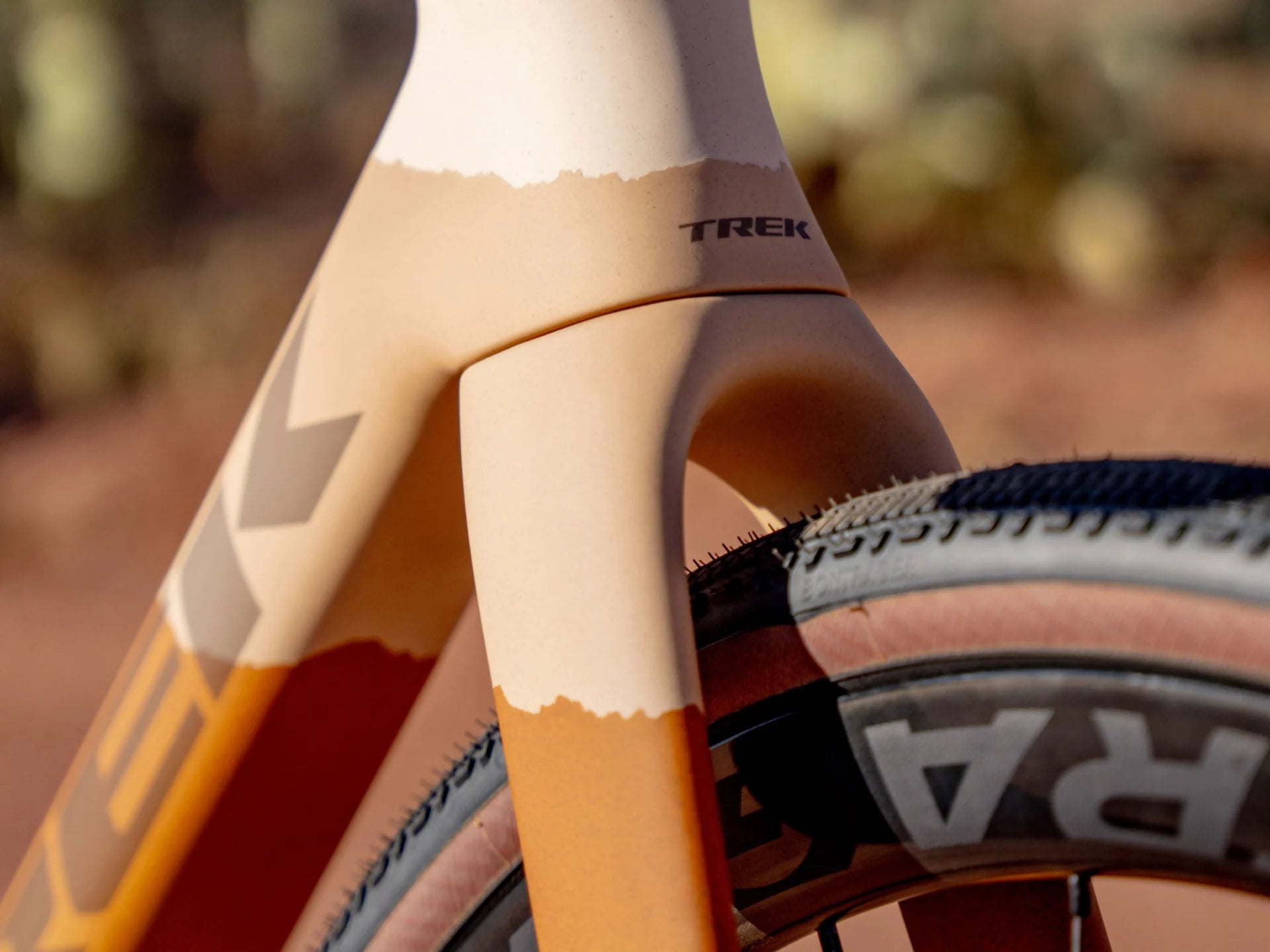 Nahaufnahme eines beige-orangen Trek-Fahrrads mit grobstolligem Reifen, geeignet für offroad Abenteuer.