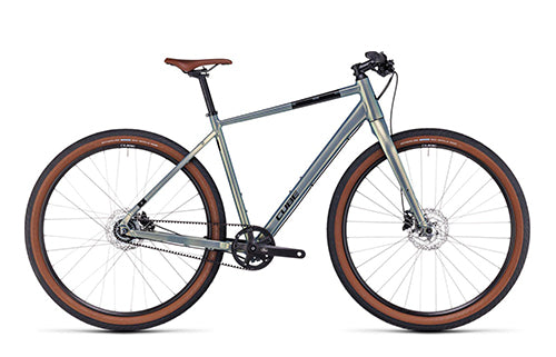 Graues Cube Hyde Fahrrad mit braunen Reifen und Ledersattel, geeignet für Stadtfahrten und Freizeitzwecke.