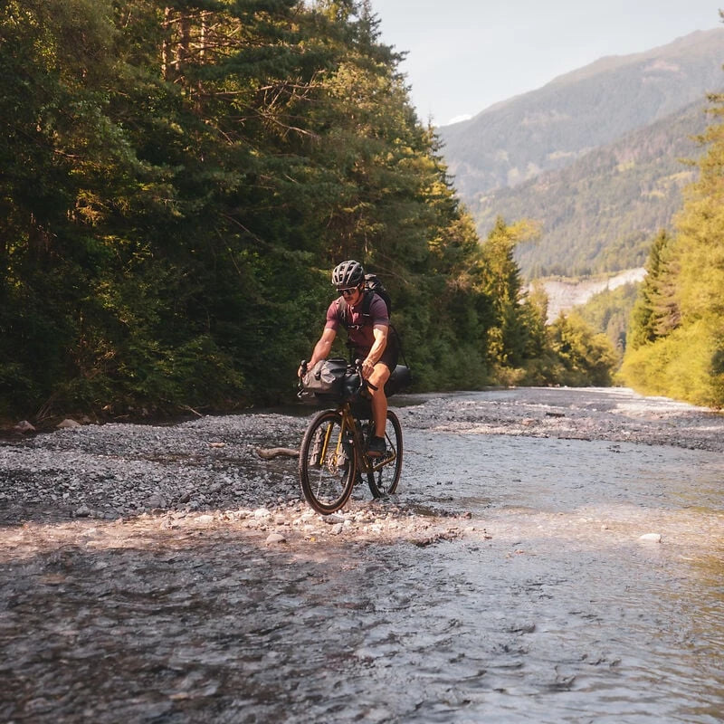 Radfahrer auf Schotterweg in Waldlandschaft, fährt Cube Gravel Bike, ideal für Outdoor-Abenteuer und Offroad-Touren.