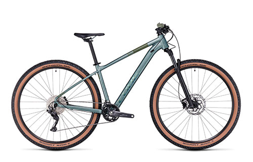 Damen-Mountainbike mit grünem Rahmen, dicken Reifen und Federgabel, optimal für Offroad-Fahrten und sportliche Käuferinnen.