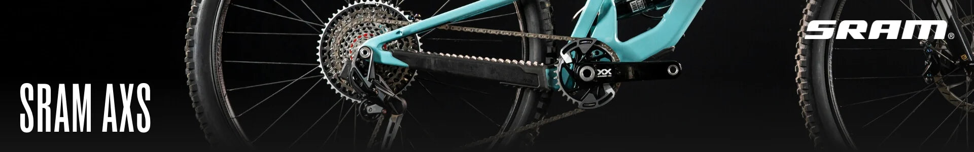 Nahaufnahme eines SRAM AXS Fahrradantriebs mit Kette, Zahnkranz und Kurbel auf einem Mountainbike-Rahmen.