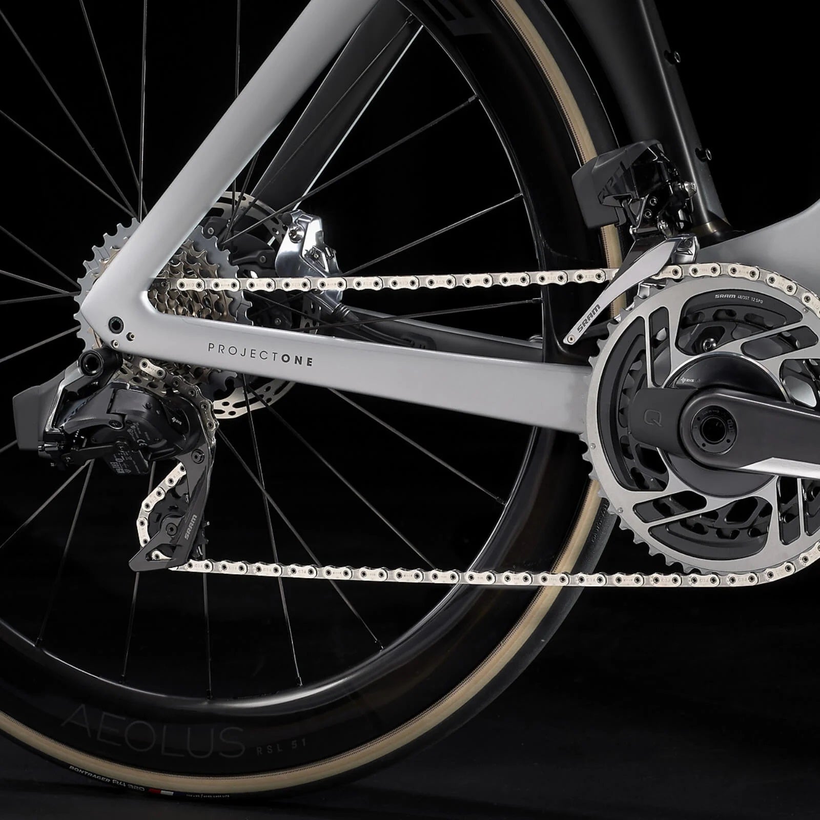 Nahaufnahme eines Trek Madone Rennrad-Antriebsstrangs mit Kette, Kurbel und Schaltwerk im Fokus.