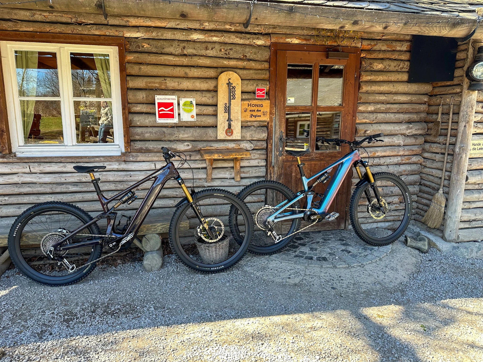 Zwei Specialized Turbo Levo E-Mountainbikes vor einer rustikalen Holzhütte geparkt.