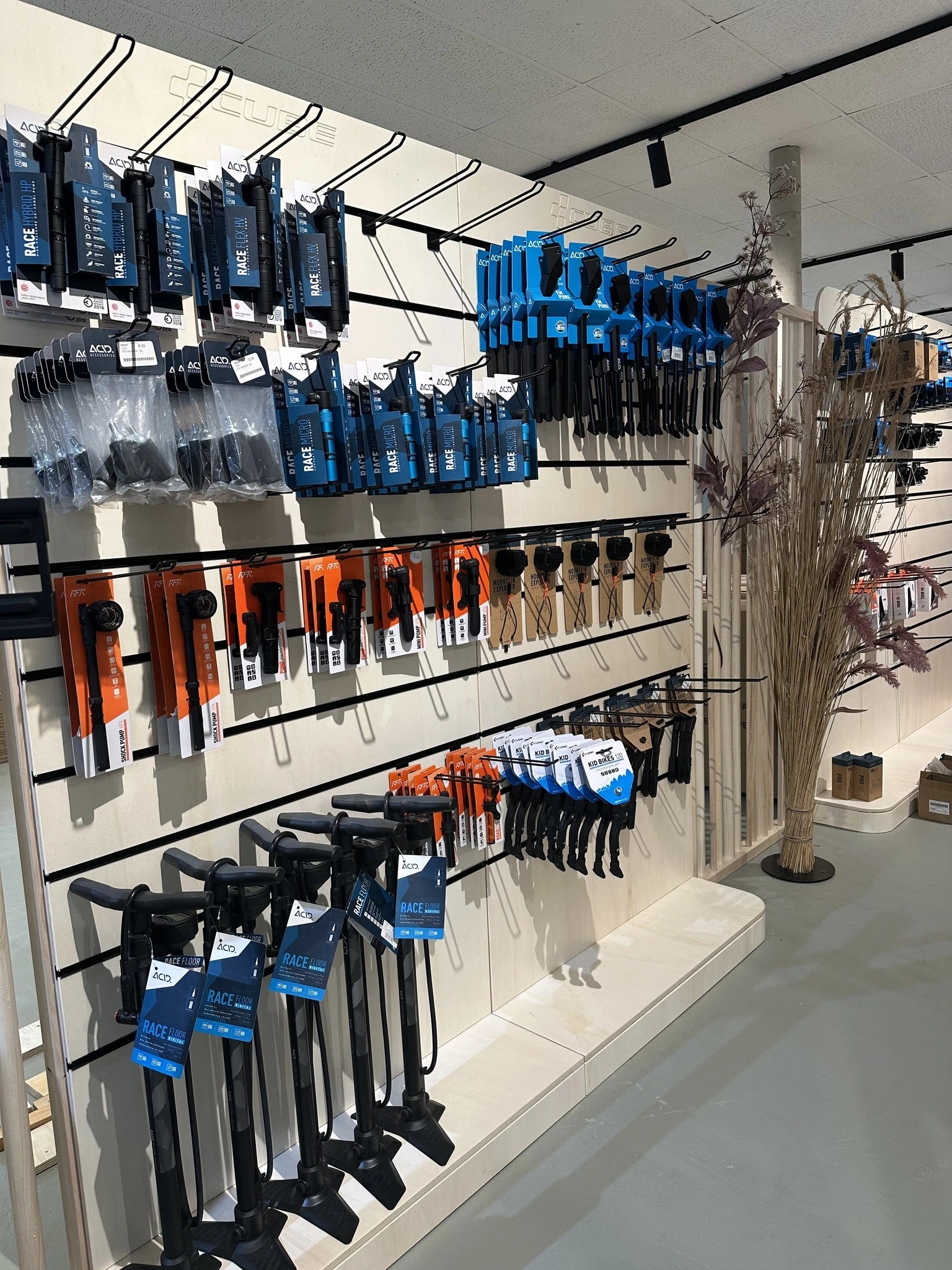 Fahrradpumpen und Zubehör in einem Geschäft, Markenname "Race", auf Regalen ausgestellt.