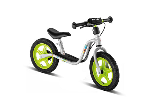 Silbernes PUKY Laufrad mit grünen Reifen, geeignet für Kleinkinder. Ideal für das Gleichgewichtstraining.