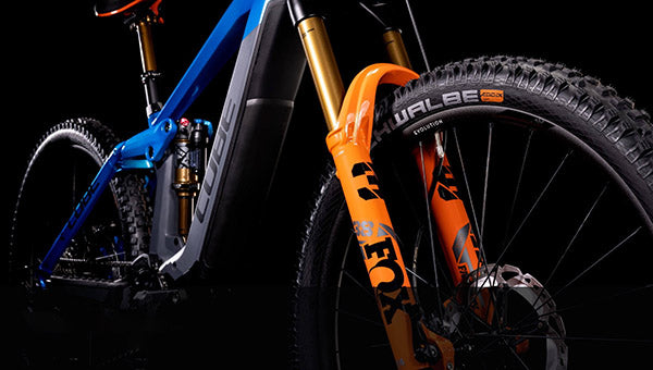 Blau-orangenes Mountainbike mit FOX-Federgabel und Schwalbe-Reifen, geeignet für Offroad-Abenteuer.
