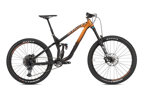 Mountainbike mit schwarzem und orangem Rahmen, Scheibenbremsen und grobstolligen Maxxis-Reifen, geeignet für Gelände.