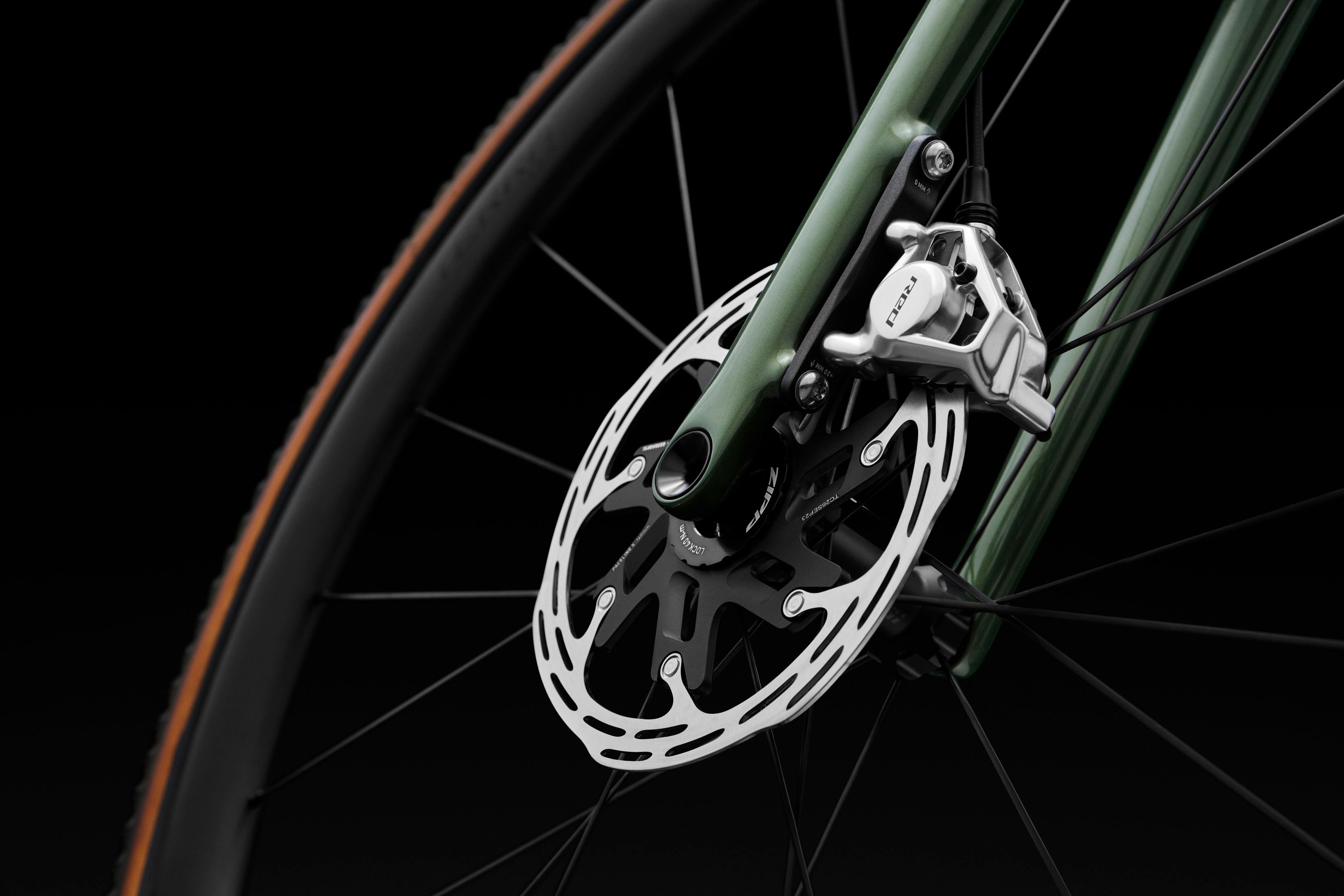 Nahaufnahme einer Scheibenbremse eines Specialized Crux Fahrrads mit grünem Rahmen und schwarzen Speichen.