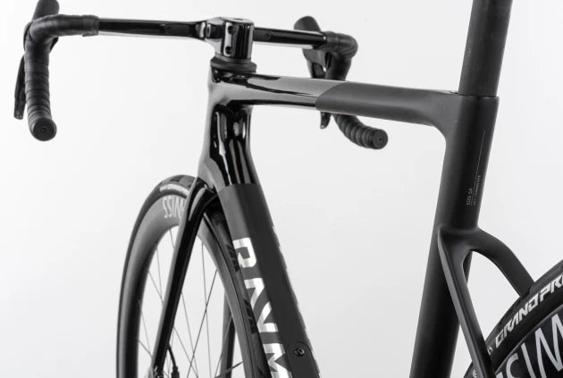 Schwarzes Rennrad Raymon Kirana, Fokus auf Rahmen und Lenker, für Straßenrennen und sportliche Radfahrer geeignet.