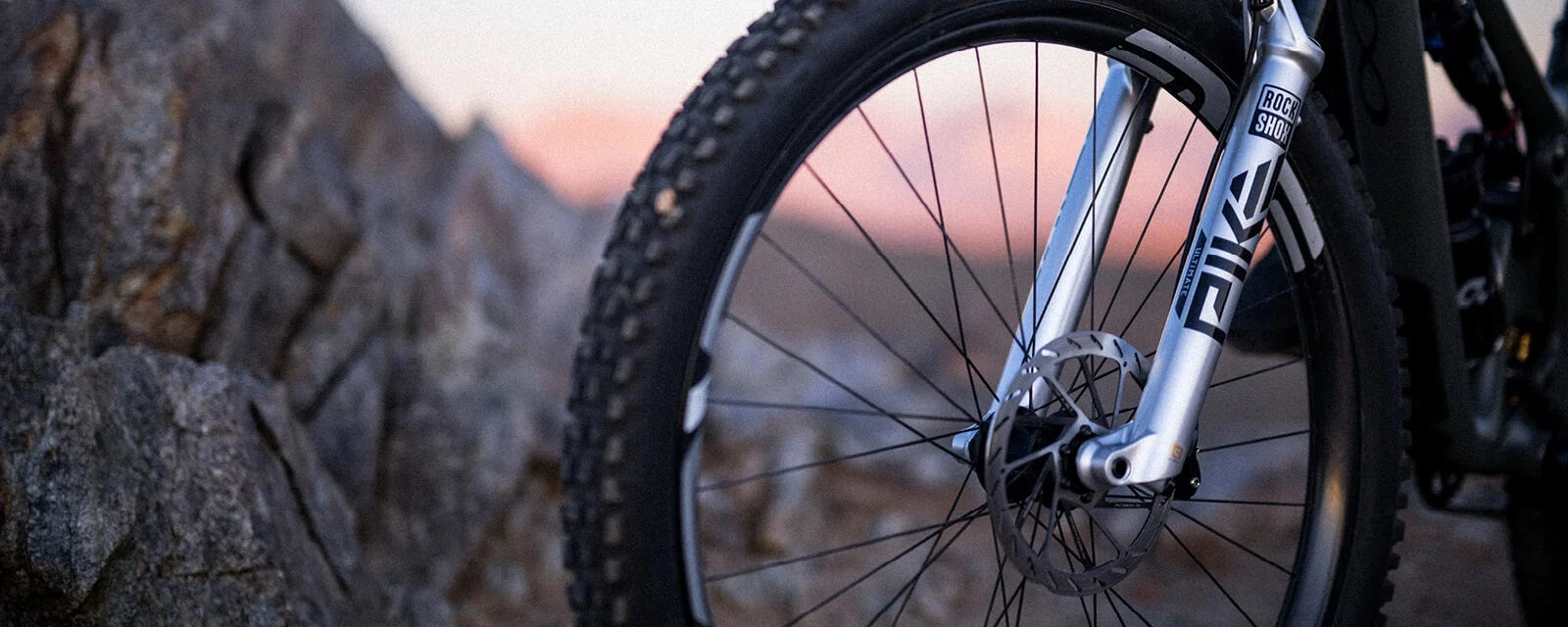 Nahaufnahme einer RockShox Pike Mountainbike-Federgabel neben einem Fels, ideal für Geländefahrten.
