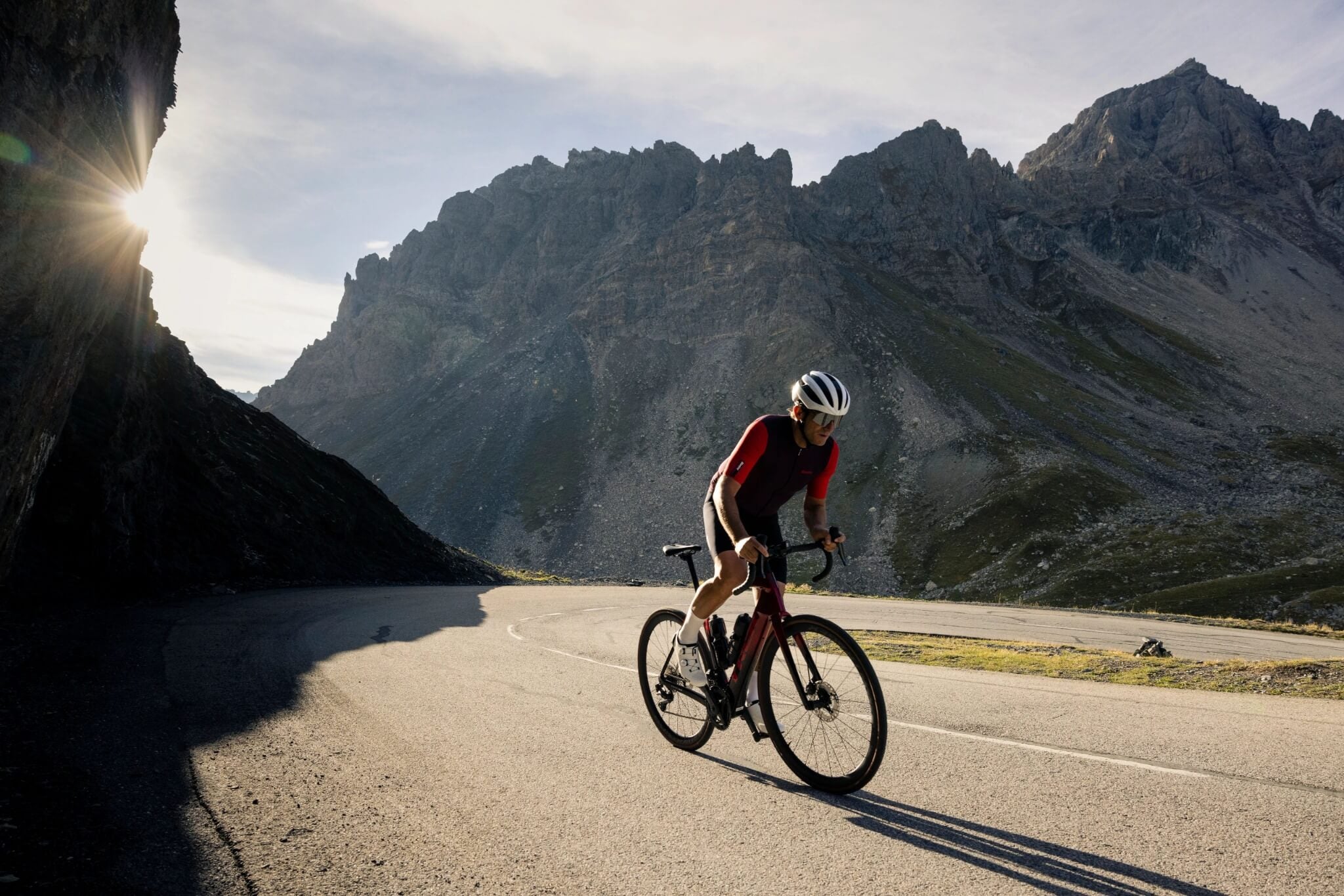 Radfahrer auf einem Trek-Rennrad fährt bergauf in sonniger Berglandschaft. Ideal für sportliche Radtouren.