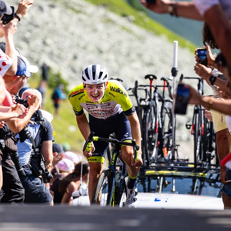 Radfahrer im Rennen auf einer Bergstrecke, umgeben von Zuschauern, auf einem Cube Litening Fahrrad.