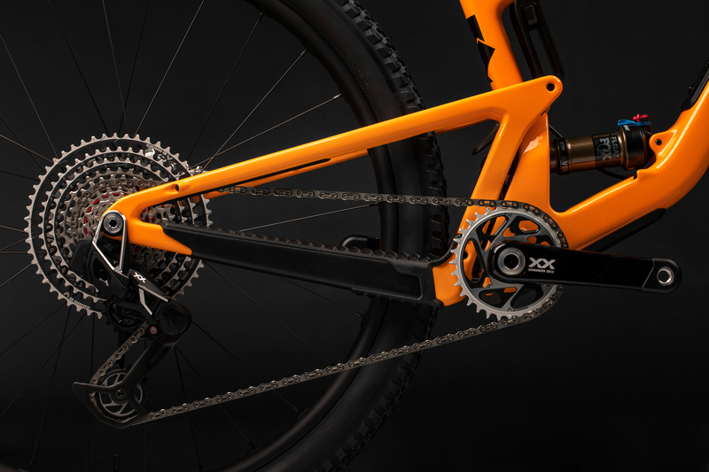 Orangefarbenes Santa Cruz Tallboy Mountainbike, Detailansicht des Hinterrads und Antriebsstrangs, Federung und Zahnkranz sichtbar.