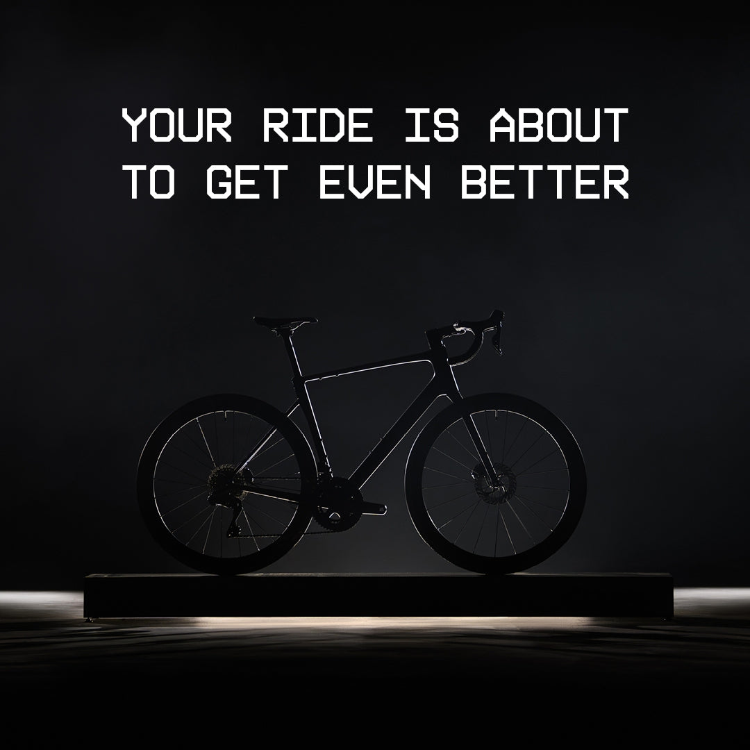 Rennrad Cube Attain, Seitenansicht, dunkler Hintergrund, Schriftzug: "Your ride is about to get even better".