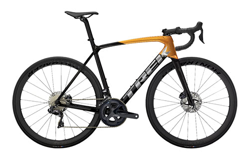 Rennrad Trek Emonda mit schwarz-orangefarbenem Rahmen, Scheibenbremsen und Rennlenker, ideal für Straßenradfahren.
