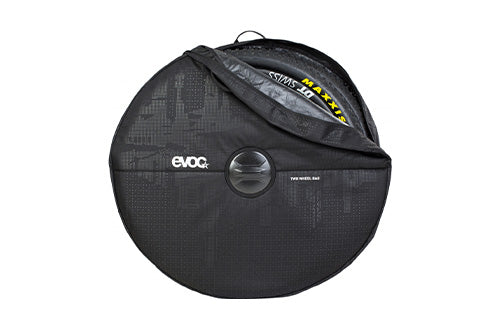 Schwarze EVOC Bike-Radtragetasche mit Reifenschutz, teils offen, Sicht auf gelbe Maxxis-Beschriftung innen.
