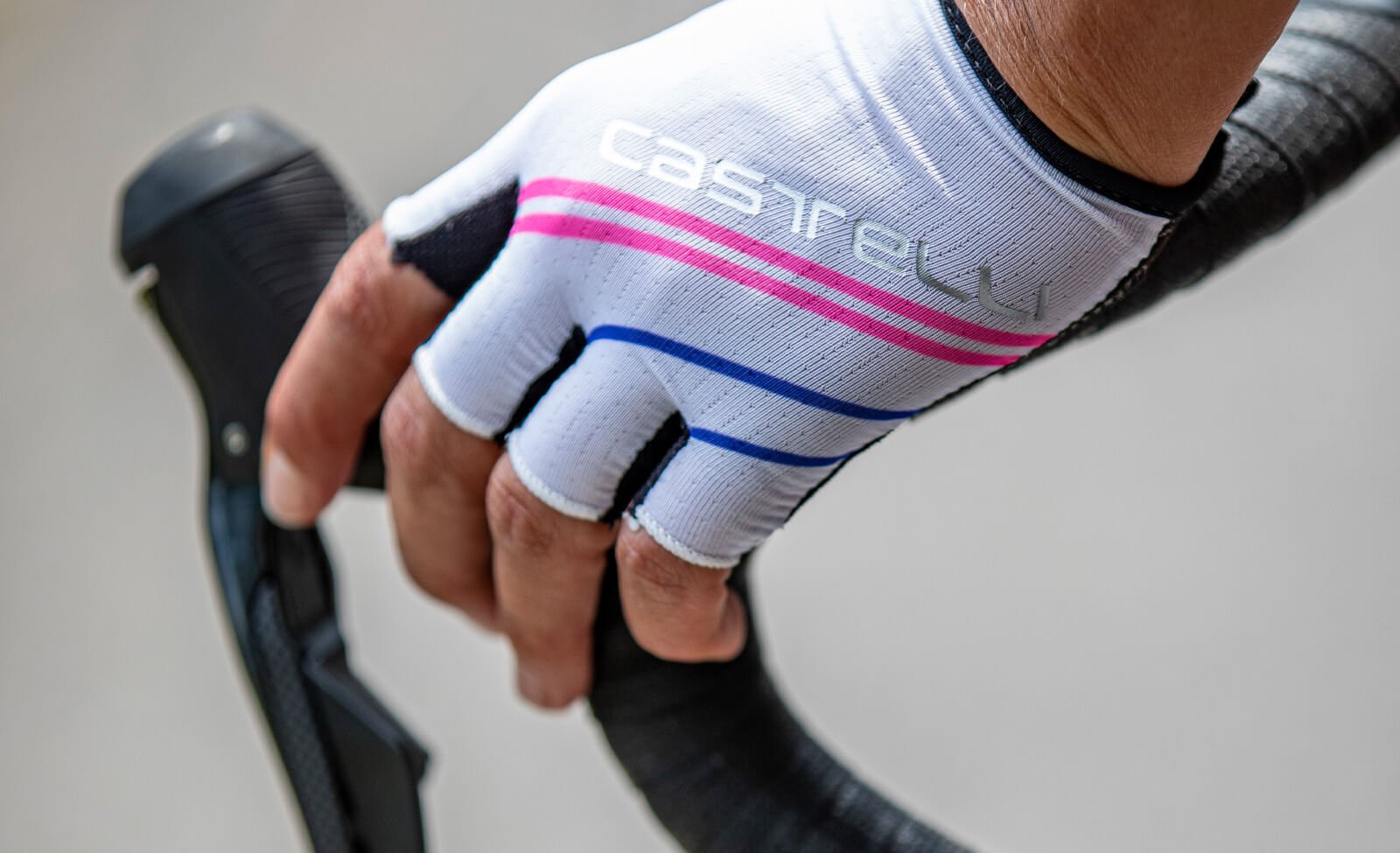 Nahaufnahme einer Hand mit Castelli-Radhandschuh, greift einen Rennradlenker, ideal für Radsportler.