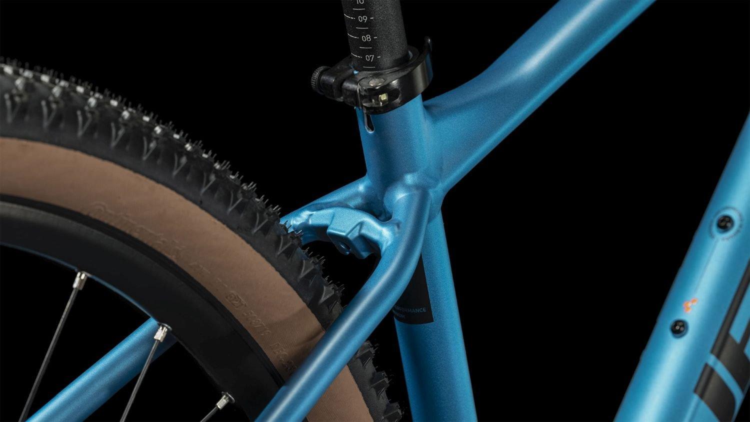 Blaues Fahrrad mit markanten Rahmendetails und Scheibenbremse, geeignet für Mountainbiking.