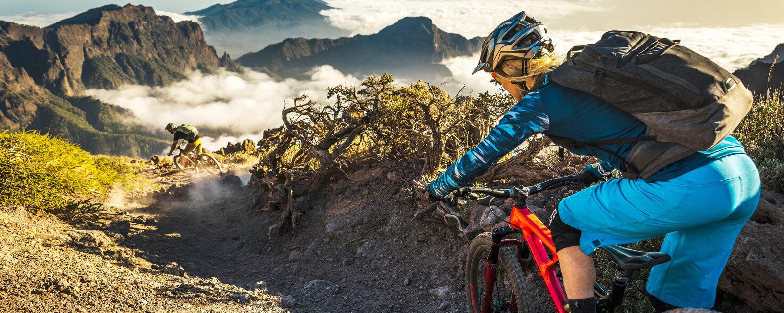 Mountainbiker auf steinigem Pfad mit Rucksack im Gebirge. Ideal für Abenteuer-Enthusiasten. (Evoc-Kollektion)