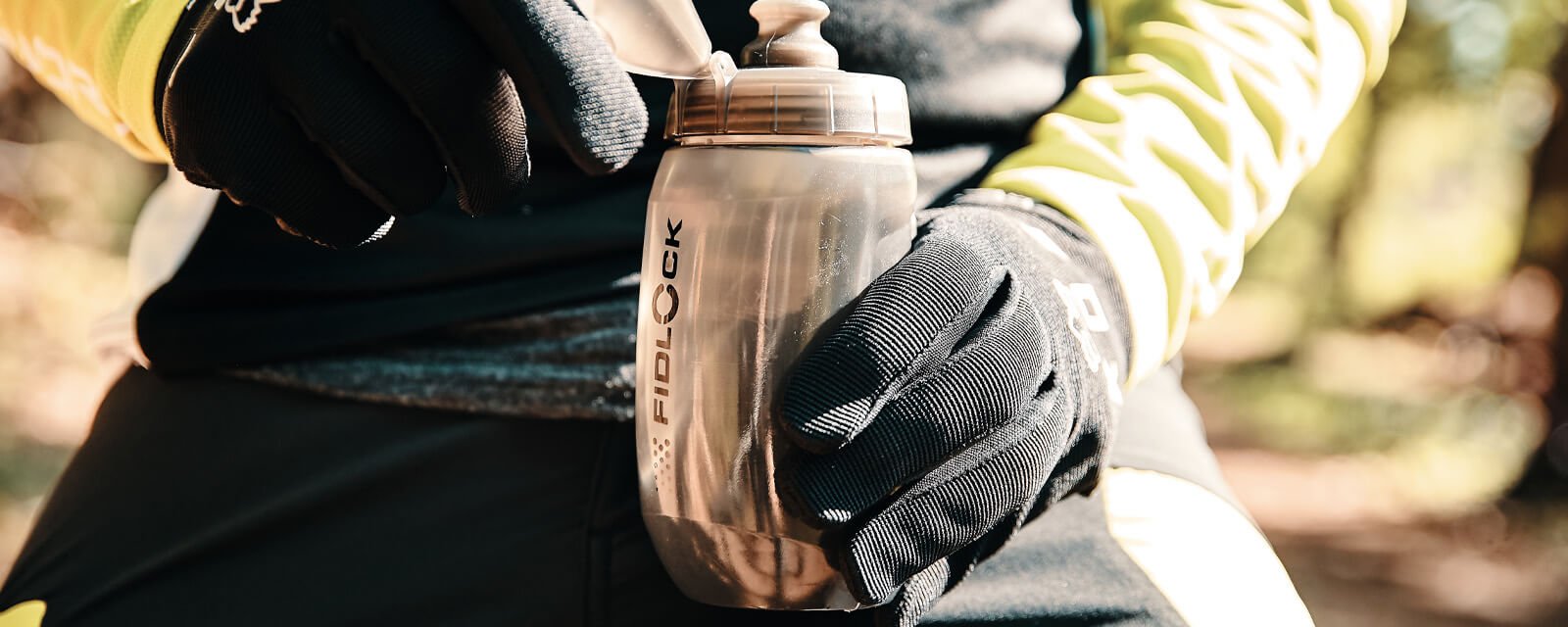 Fidlock Trinkflasche für Outdoor-Sport, in behandschuhter Hand gehalten, geeignet für Radfahrer und Abenteurer.