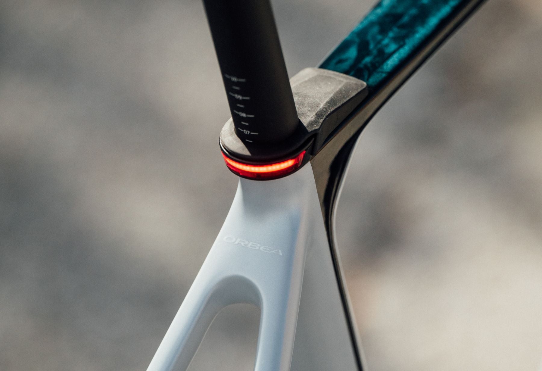 Nahaufnahme einer weißen Fahrrad-Sattelstange mit rotem Rücklicht, Marke Orbea, Modell Gain.