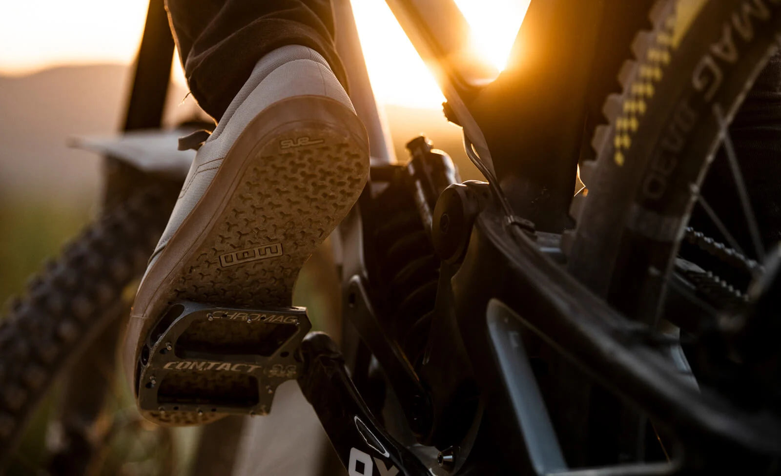 Schuhsohle auf Chromag-Flatpedal eines Mountainbikes bei Sonnenuntergang, geeignet für Radsport-Enthusiasten.