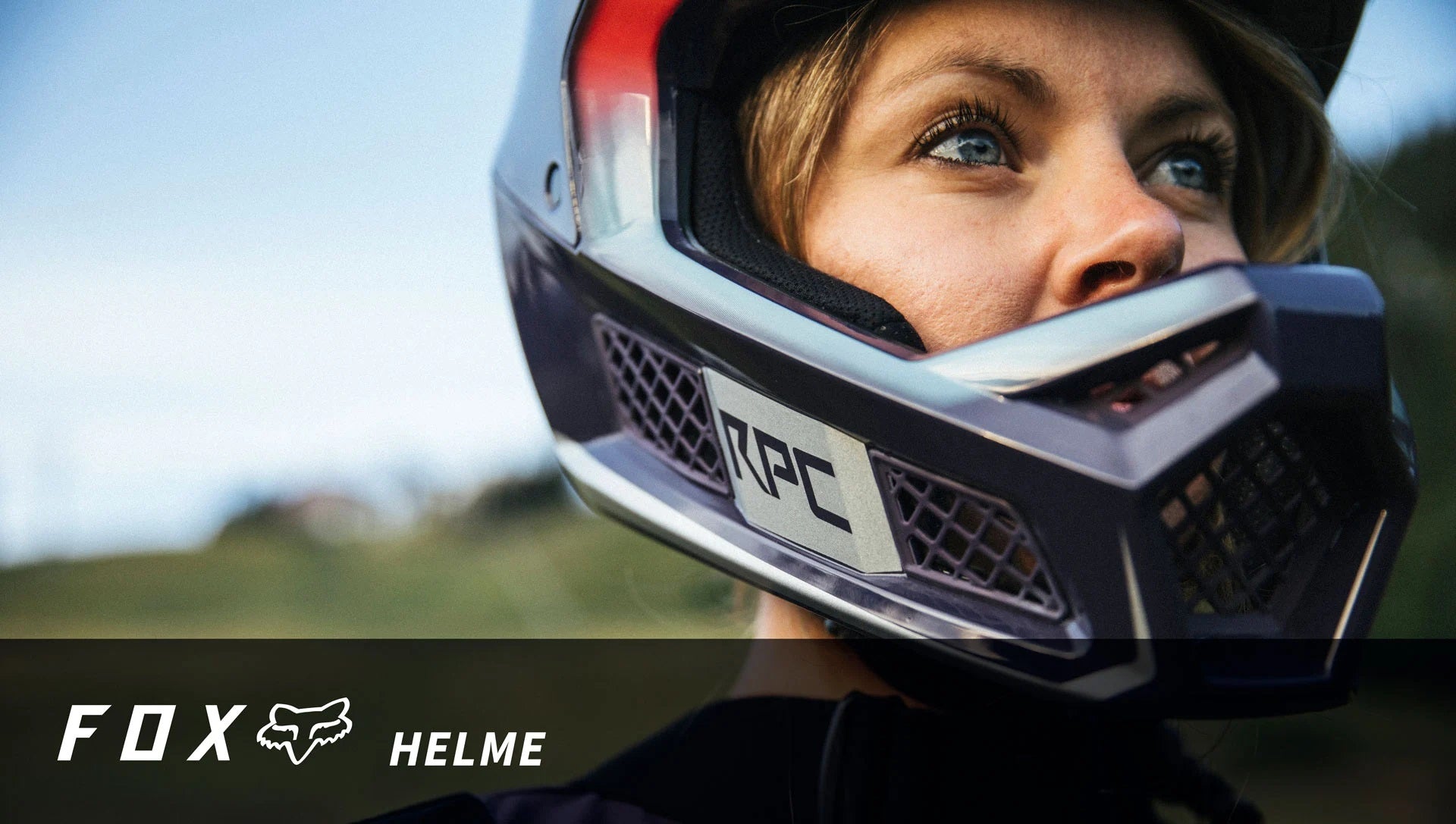 Frau trägt Fox RPC Helm für Mountainbiking. Nahaufnahme des robusten Schutzhelms mit Gitterdesign und klarem Helmvisier.