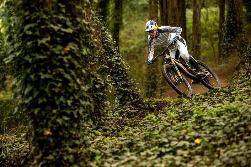 Mountainbiker fährt auf einem Santa Cruz Mountainbike durch bewaldeten Trail.