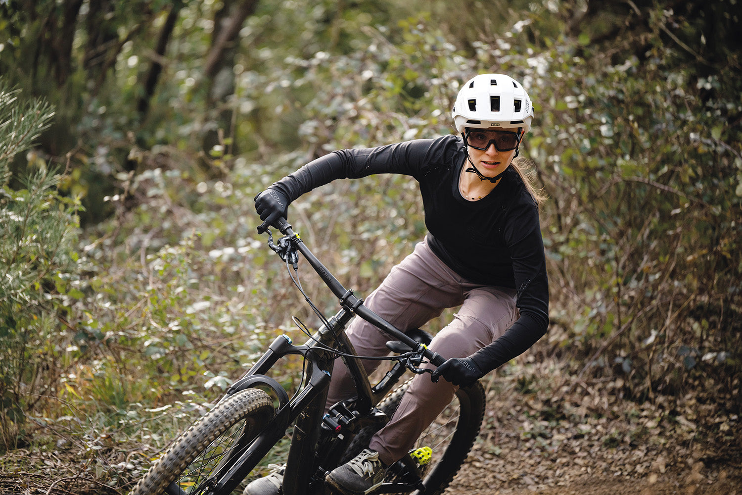 Person auf Mountainbike mit SQlab-Lenker, fährt im Wald. Trägt Helm, Brille und Handschuhe. Ideal für Mountainbiker.