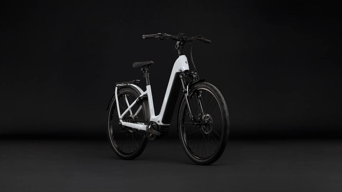 Weißes E-Bike CUBE KATHMANDU HYBRID DELUXE PRO 800 mit tiefem Einstieg und Scheibenbremsen, ideal für Stadtfahrten; schwarzer Hintergrund.