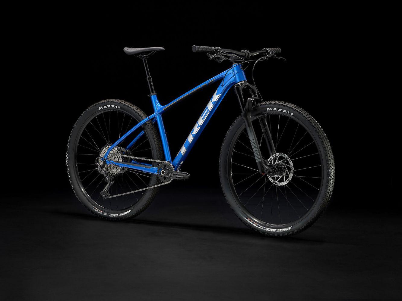 Blaues Trek Hardtail Mountainbike, geeignet für Offroad-Abenteuer, mit RockShox-Gabel und Maxxis-Reifen.