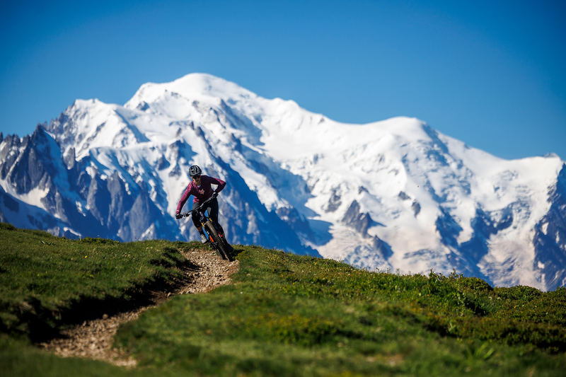 Mountainbiker auf dem Trail vor schneebedecktem Bergpanorama, fährt Santa Cruz Hightower, geeignet für Outdoor-Abenteuer.