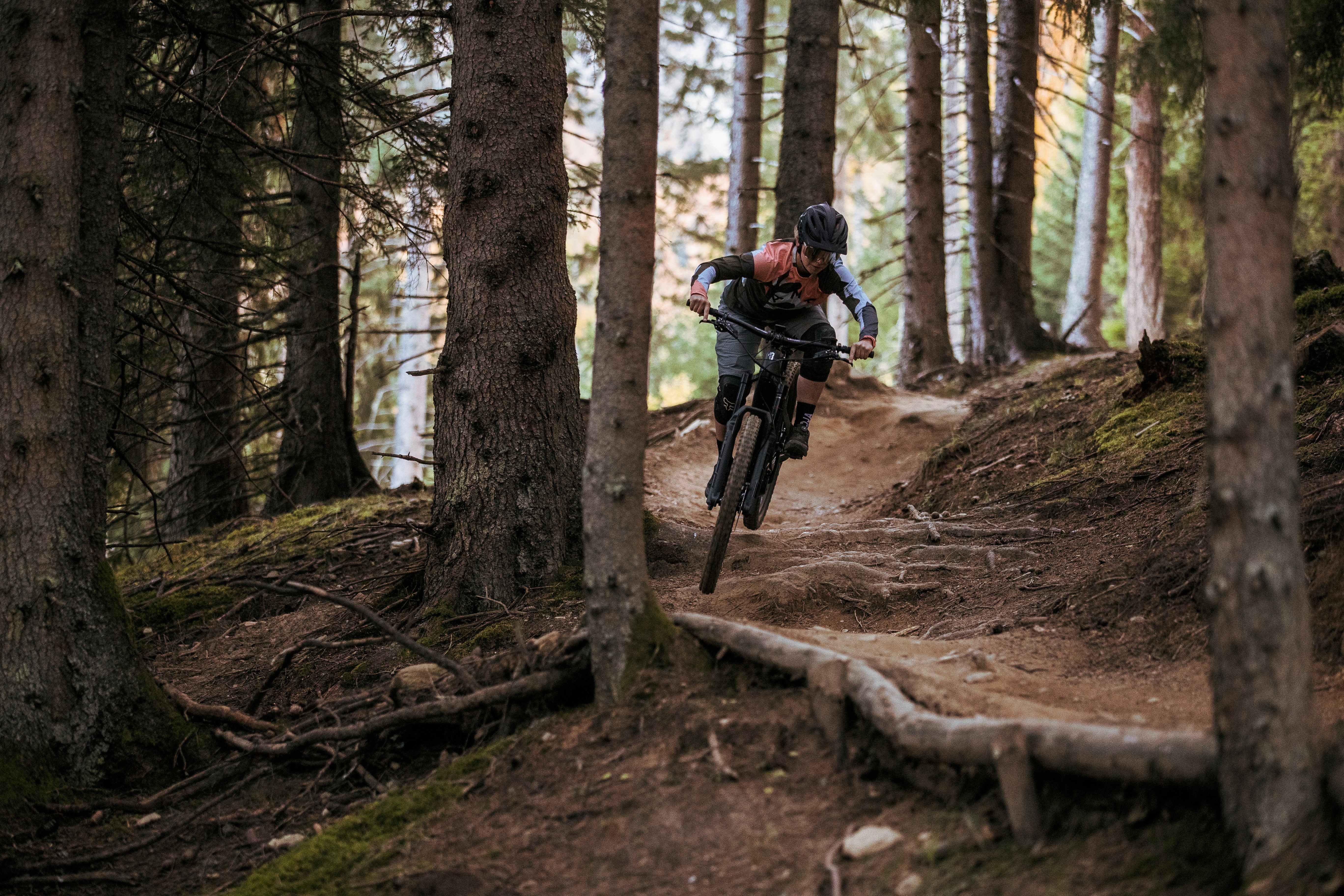 Mountainbiker fährt ein Ghost E-Mountainbike durch einen Waldpfad. Ideal für Outdoor-Abenteuer.