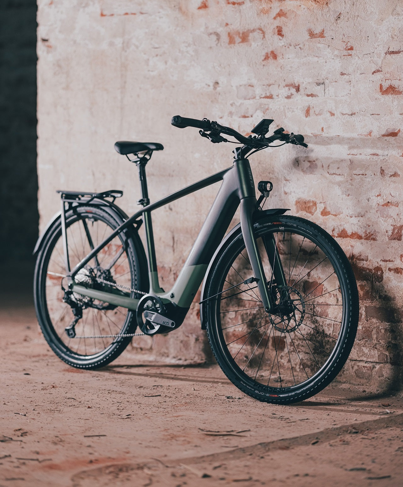 Modernes E-Bike in Grau-Grün, ideal für Stadtfahrten. Robuster Rahmen, Scheibenbremsen, Akku im Unterrohr integriert.