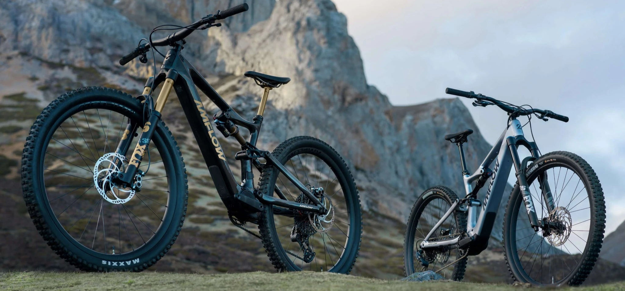 Zwei AMFLOW Mountainbikes vor Felskulisse, geeignet für Offroad- und Gebirgstouren.