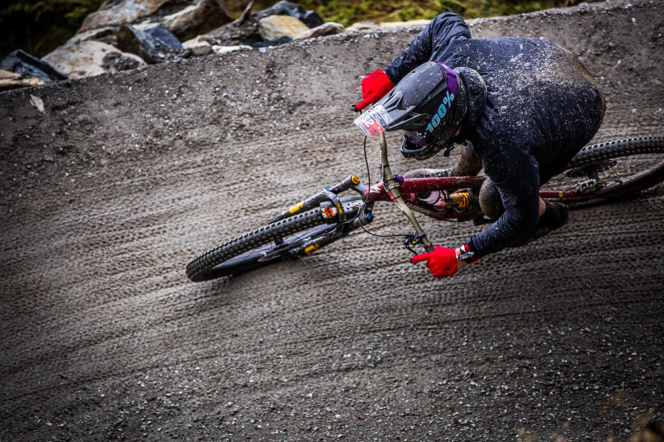 Mountainbiker in Aktion auf schlammiger Strecke, Specialized Mountainbike, geeignet für Offroad-Enthusiasten.